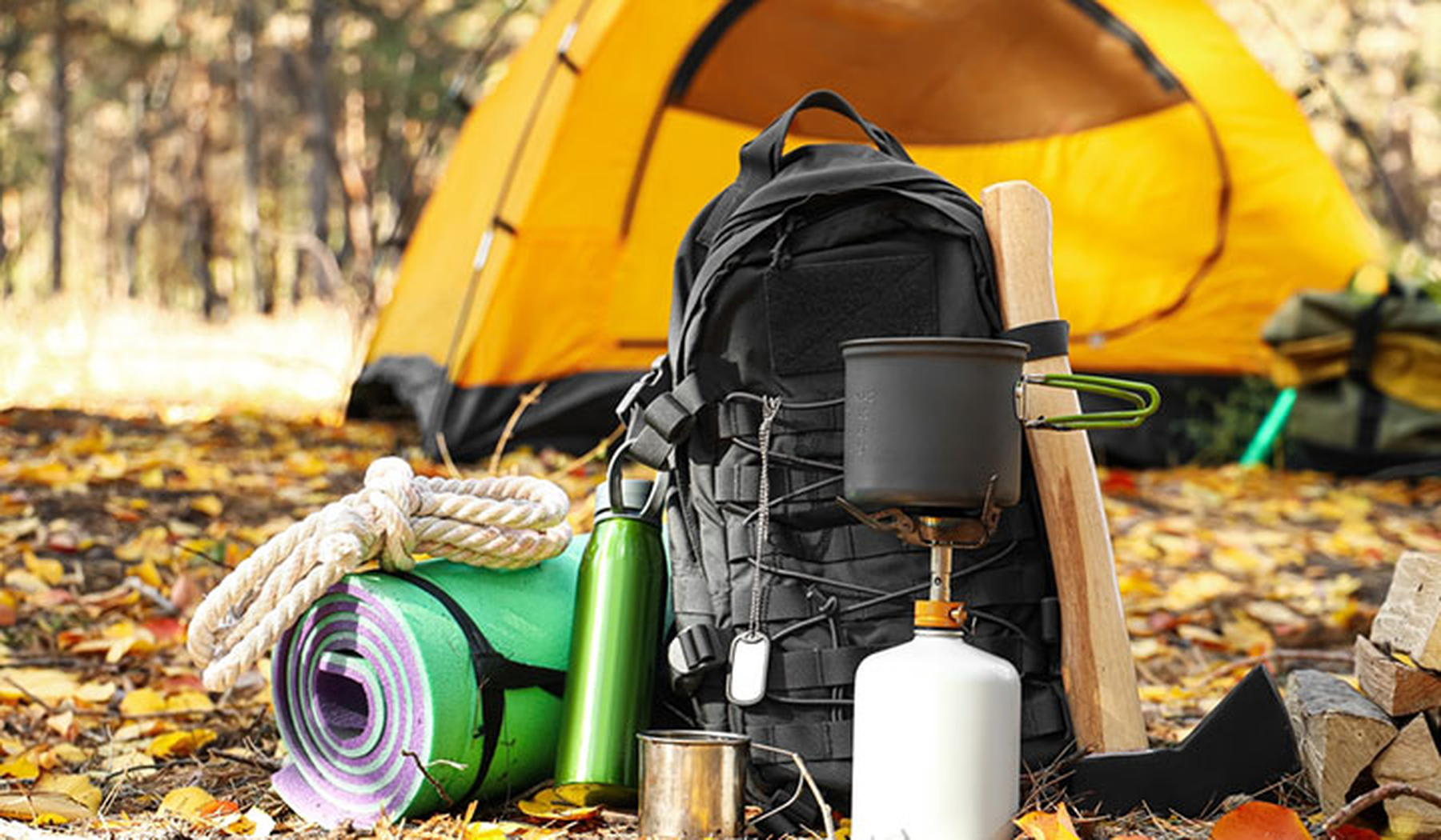Camping gear piled by a tent