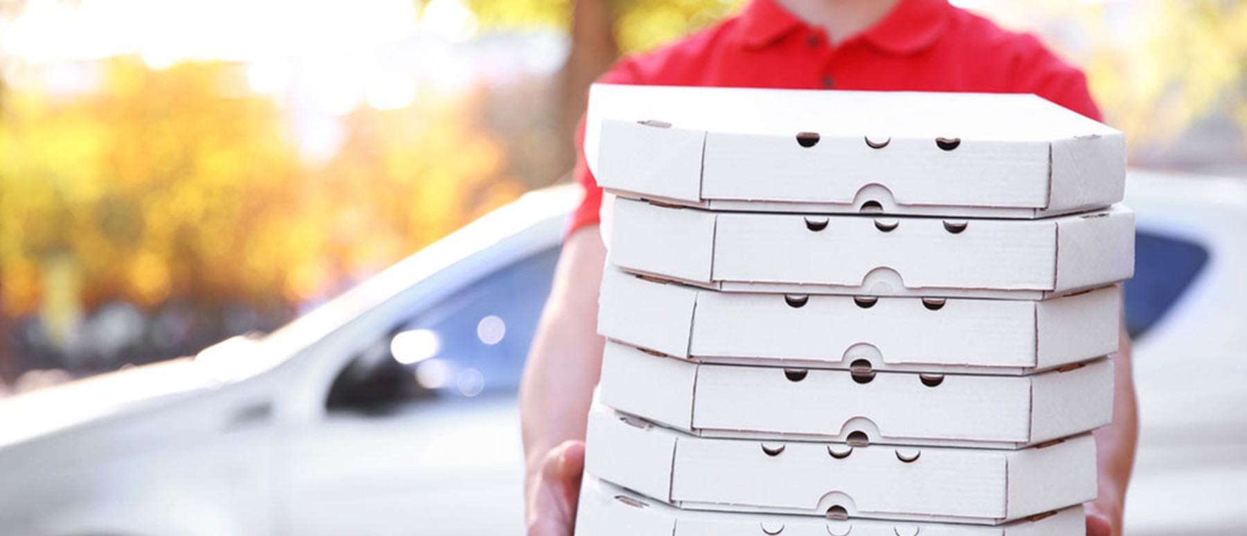 Man delivering stack of pizza boxes