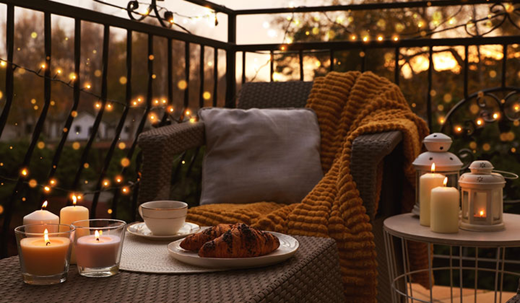 Cozy deck at dusk with string lights and candles