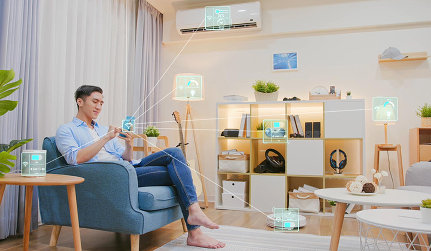 Asian man sitting with his device controlling his smart home