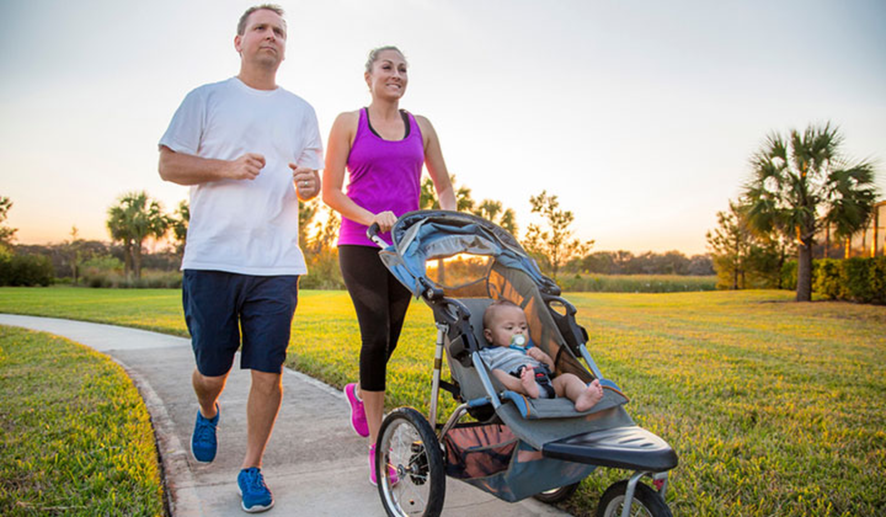 Man and woman jogging with baby in a stroller