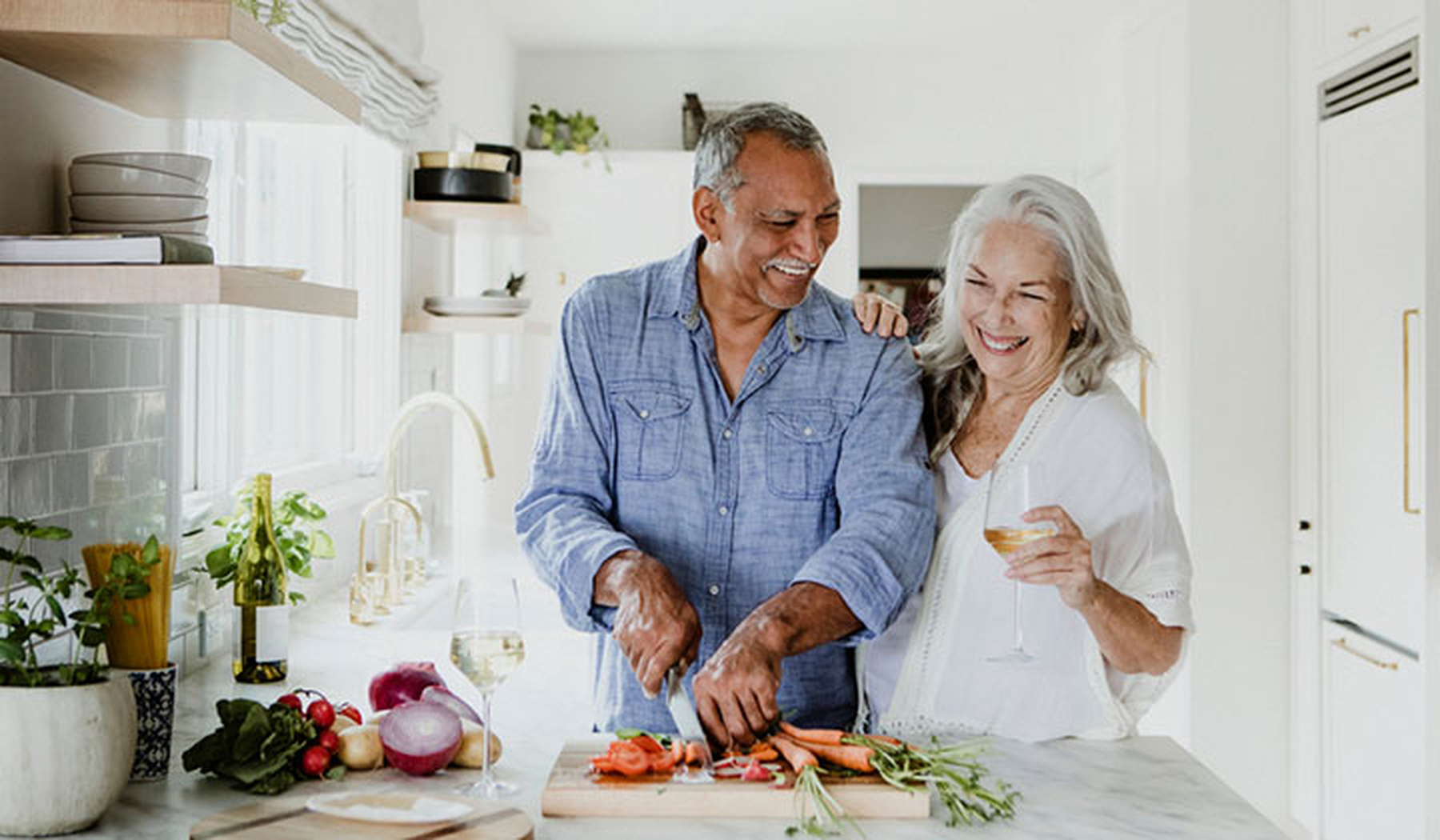 Smiling older couple cooking together in the kitchen