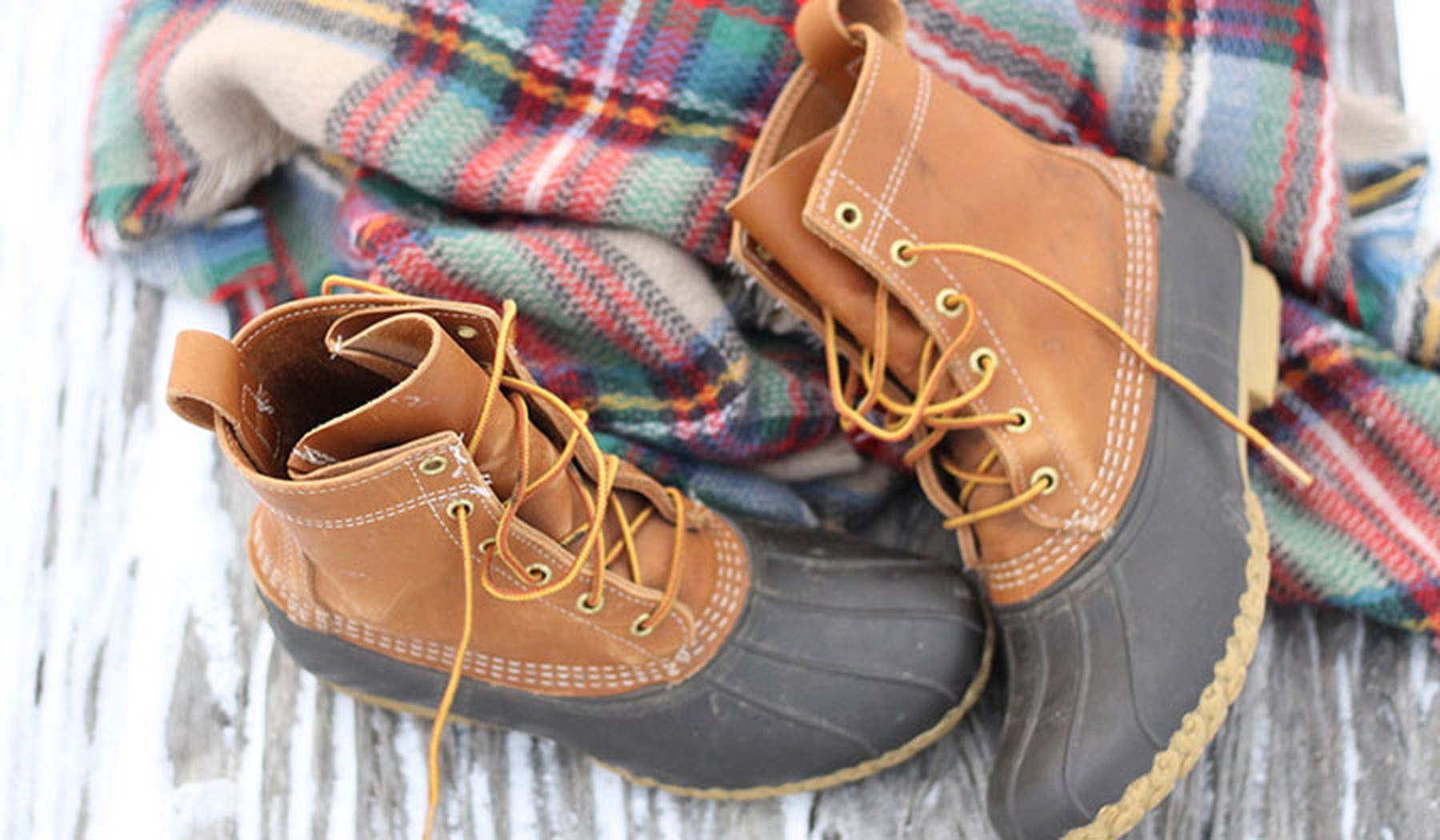 LL Bean Duck boots on red and green flannel blanket