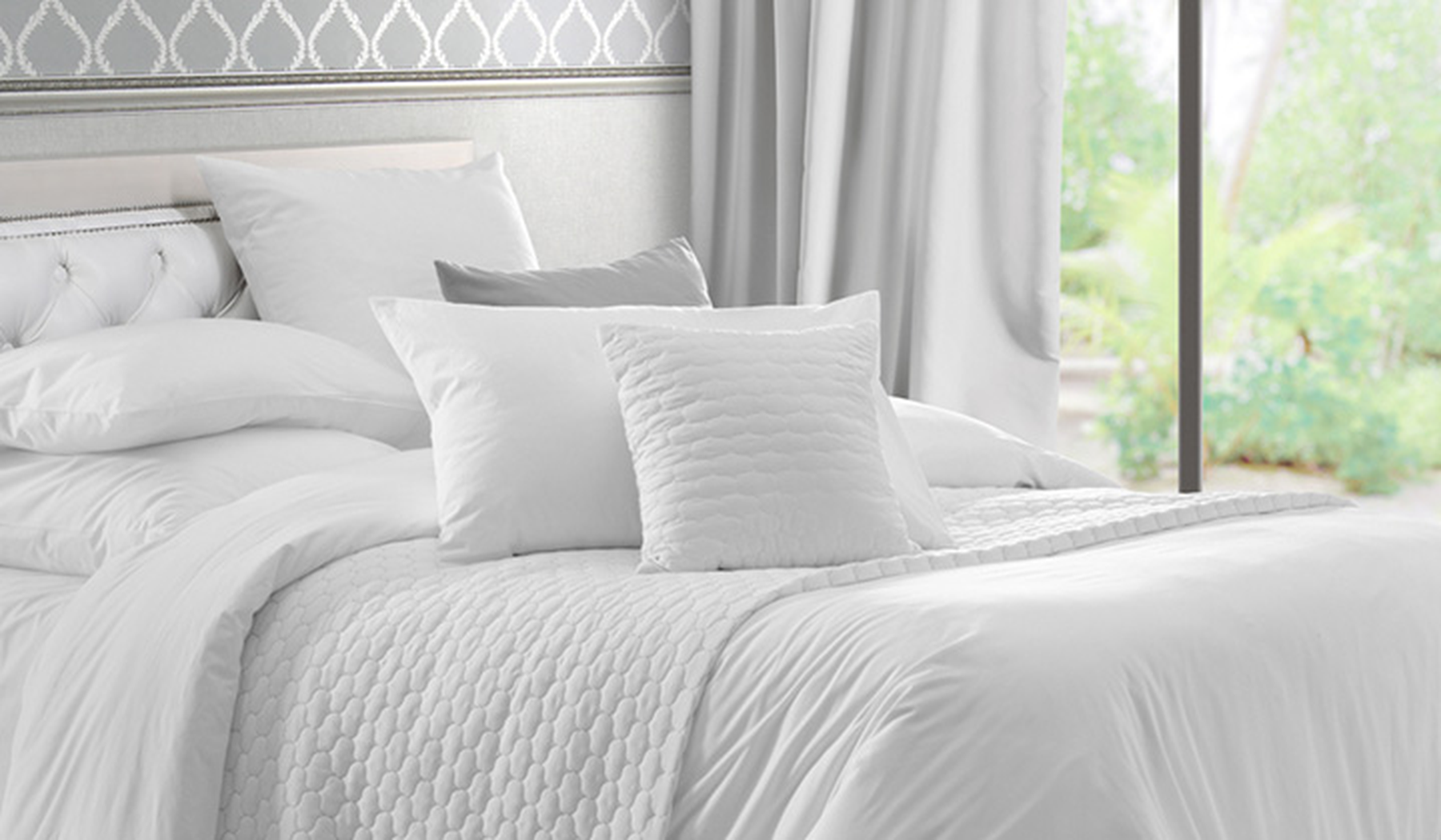 A bed with white and gray bedding