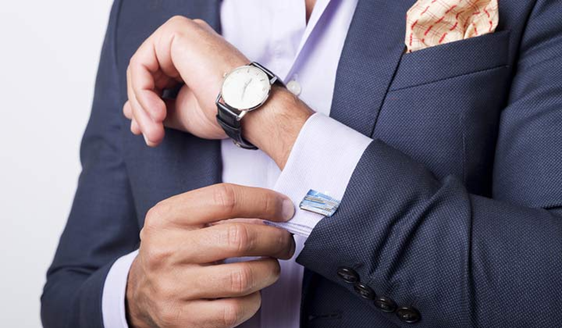 Man in a suit fixing his cufflink