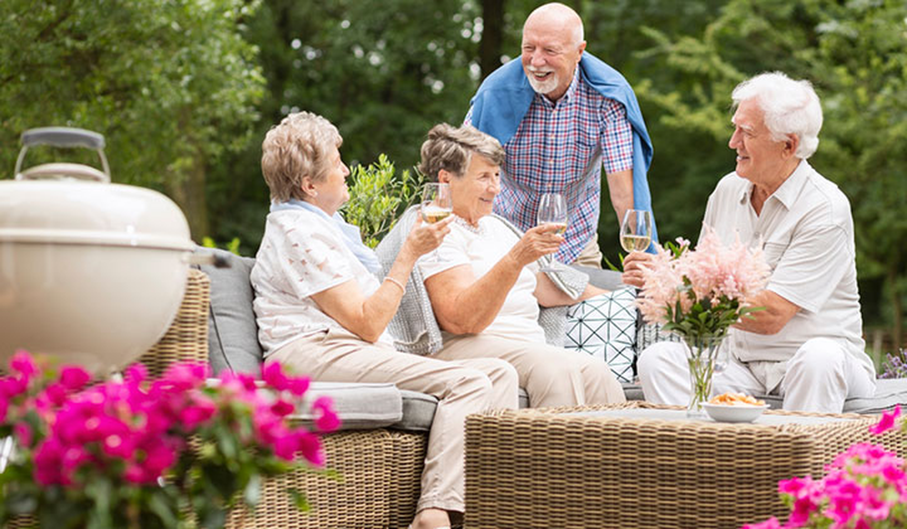 Two older couples sitting outside on a patio set