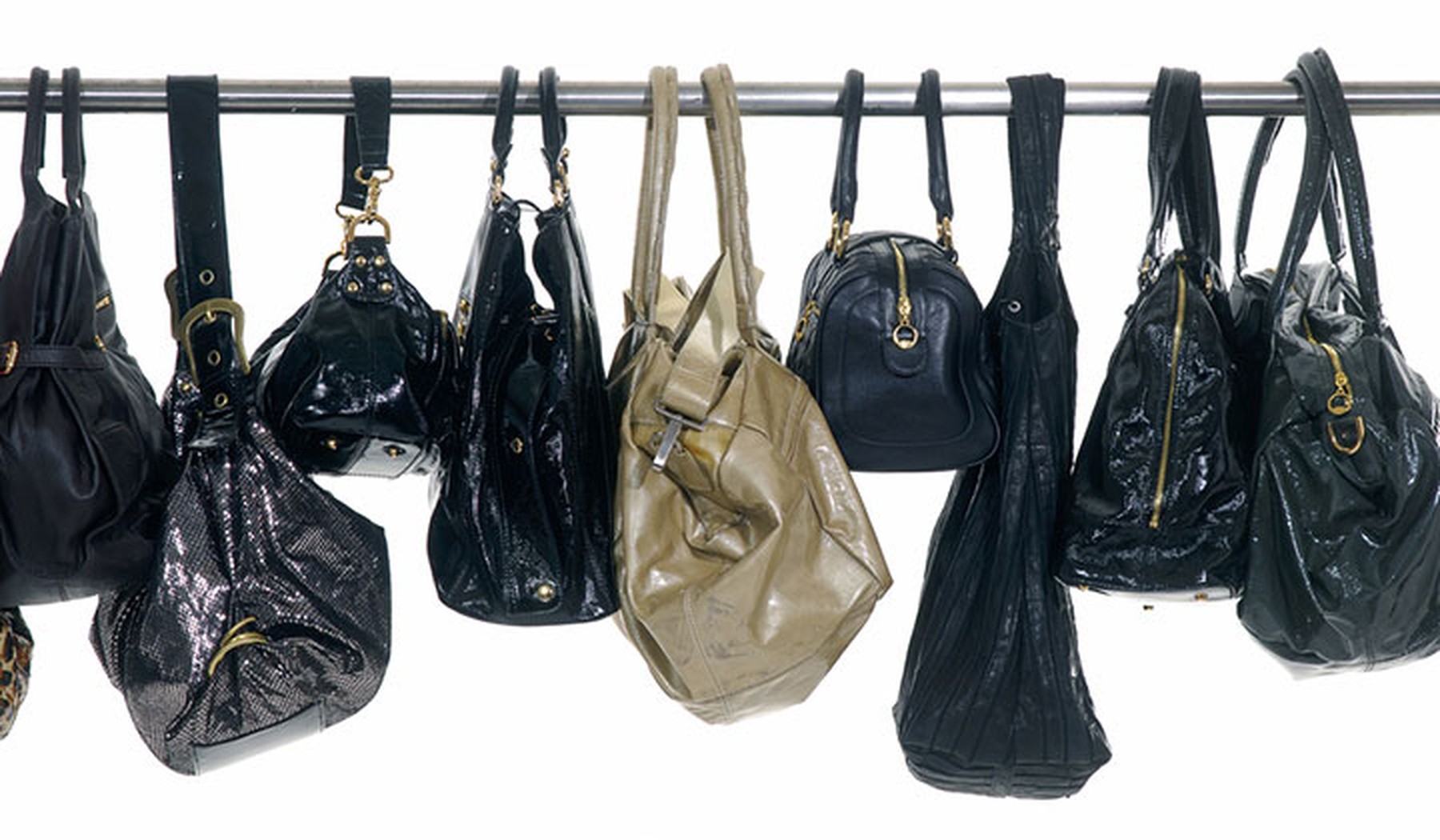 Black and gold purses hanging on a rod