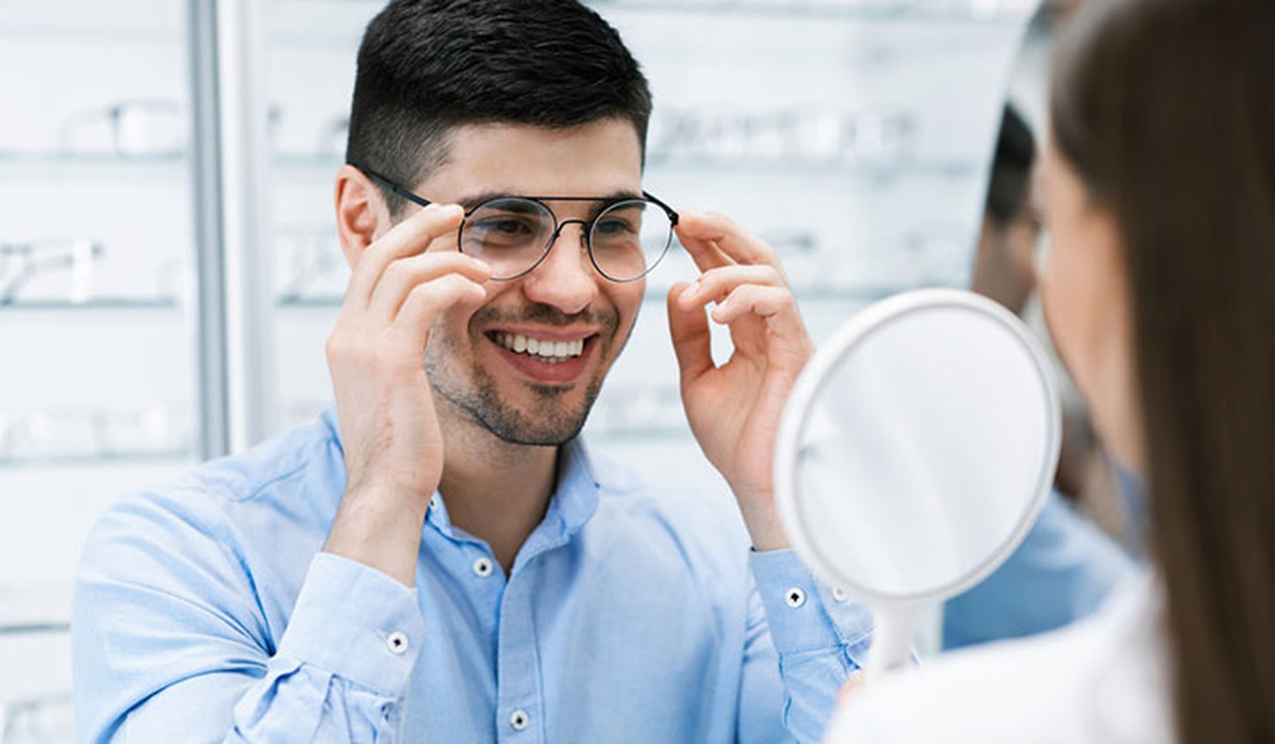 Young man trying on eyeglasses