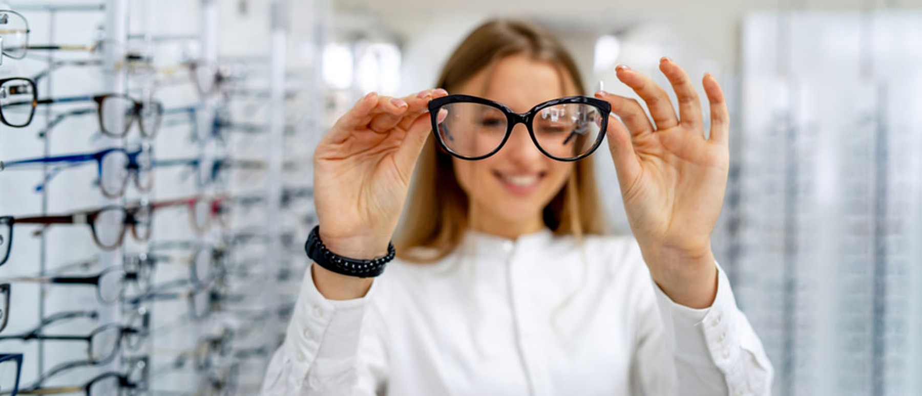Young woman holding up eyeglasses