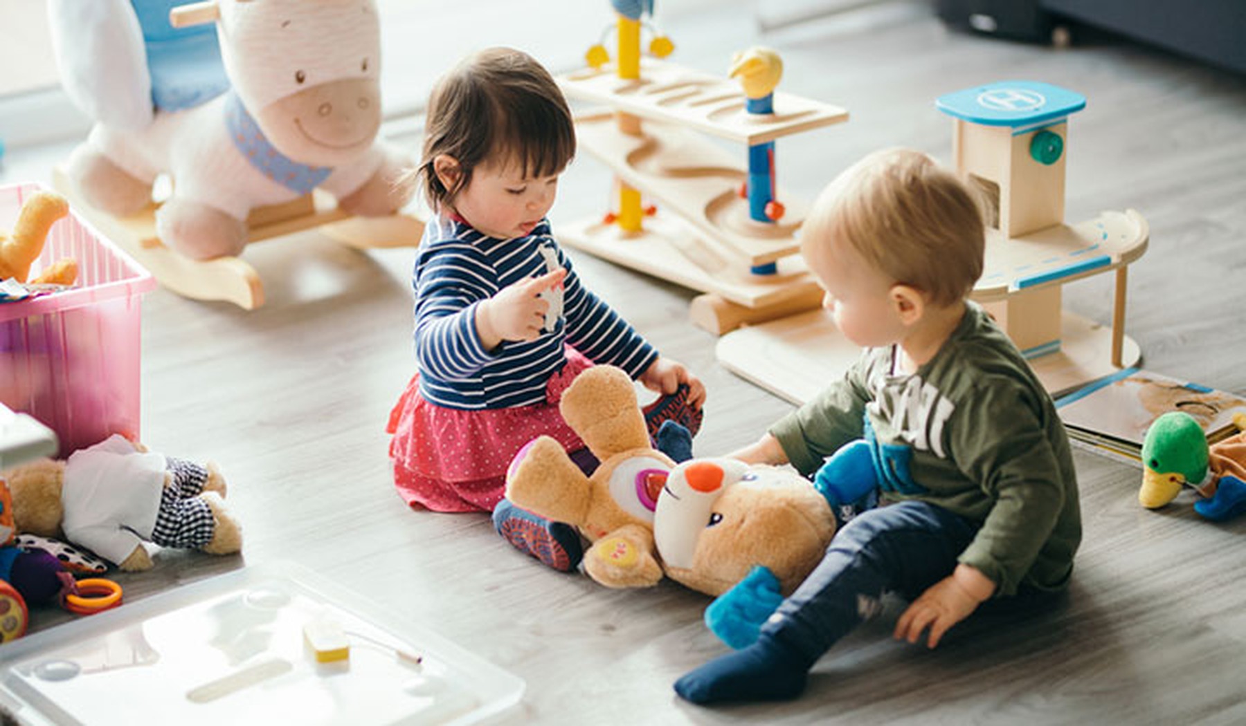 Boy and girl toddlers playing with toys