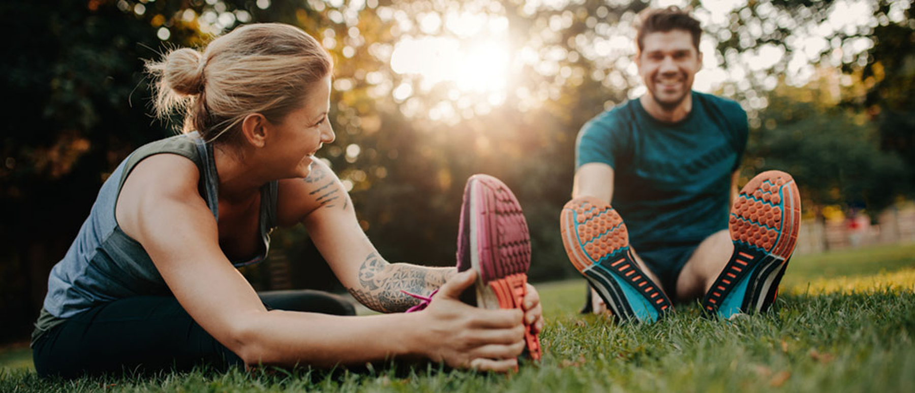 Young athletic couple stretching before a run in the park