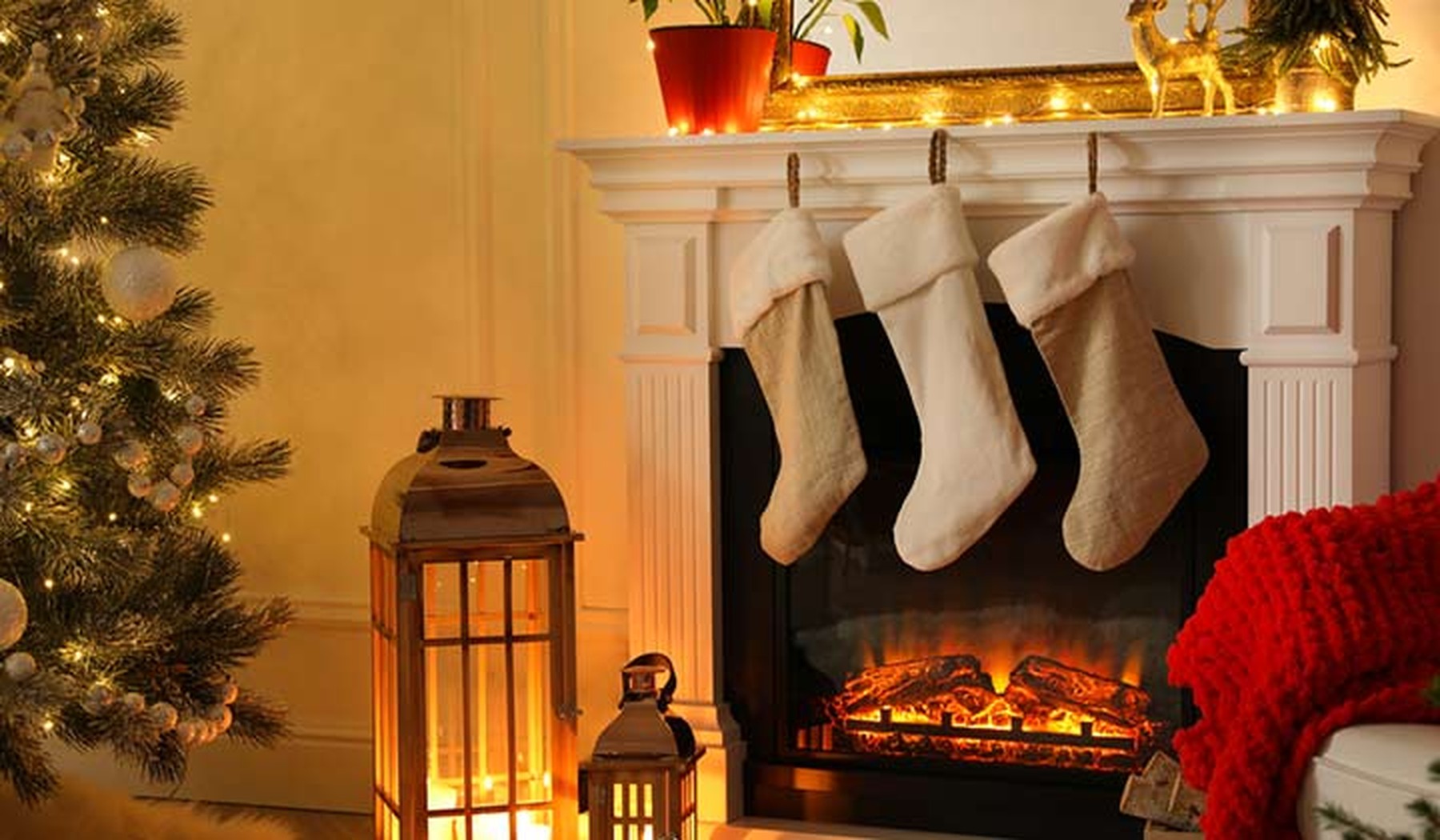 Christmas tree and stockings hung on a fireplace