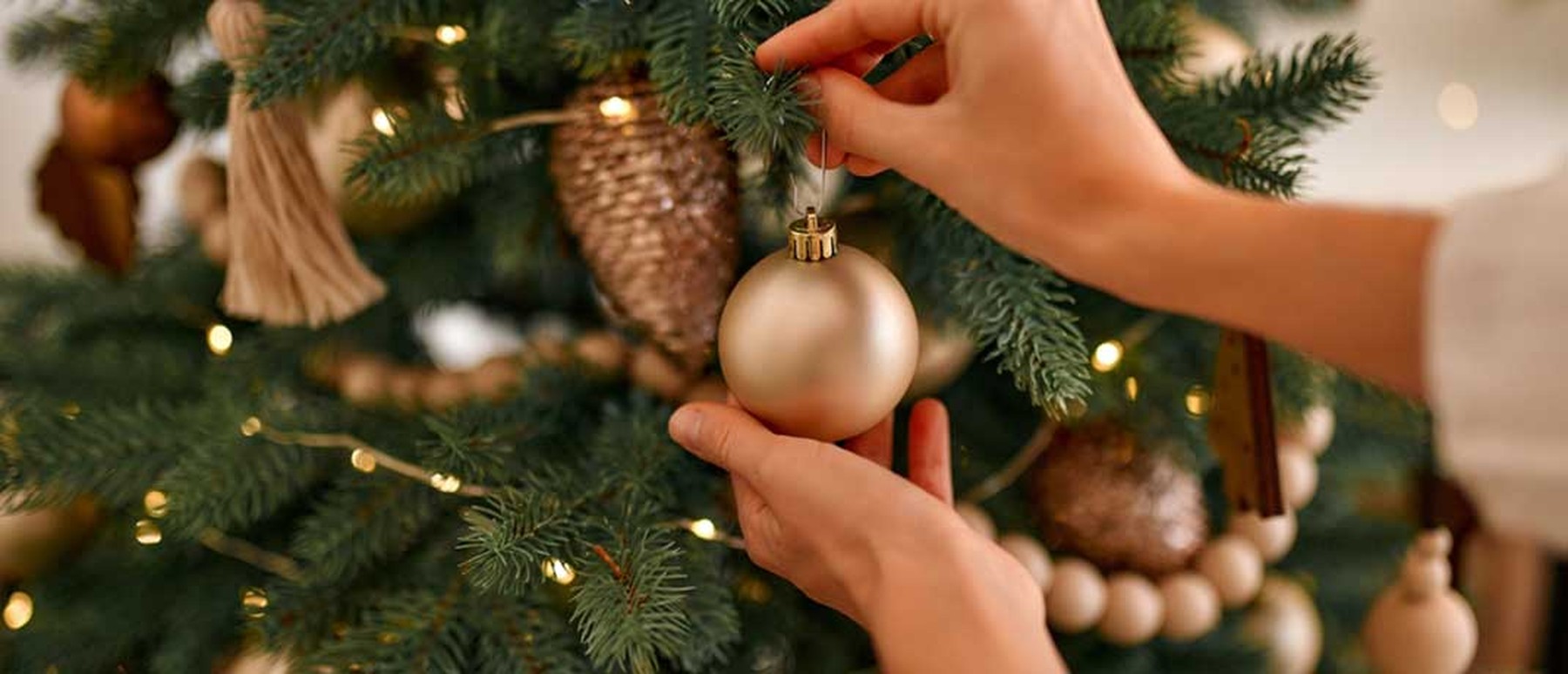 Woman putting ornaments on a Christmas tree