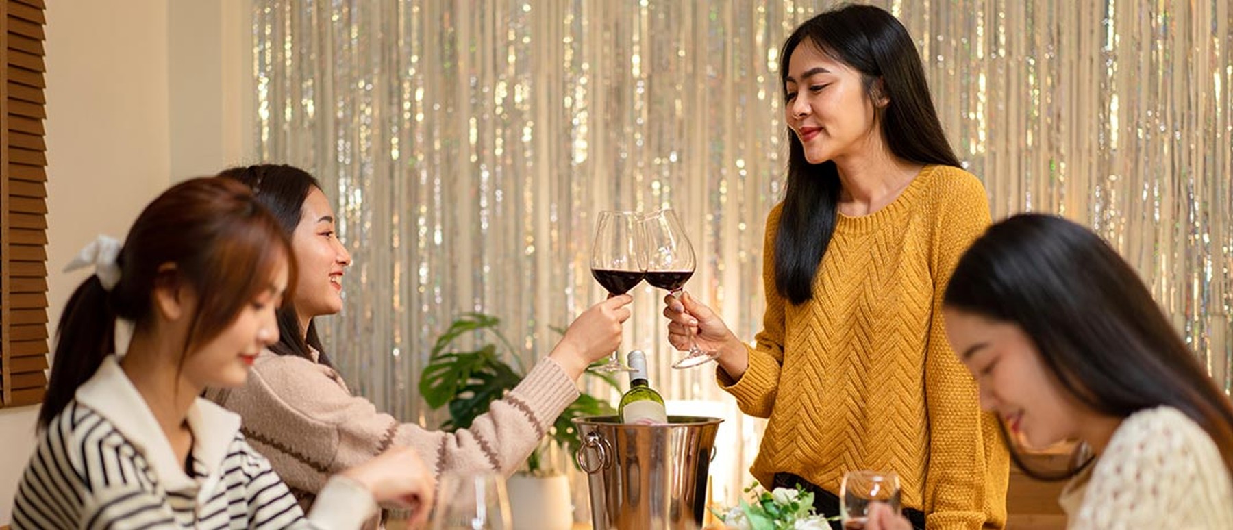 Multi-cultural women drinking wine at a party