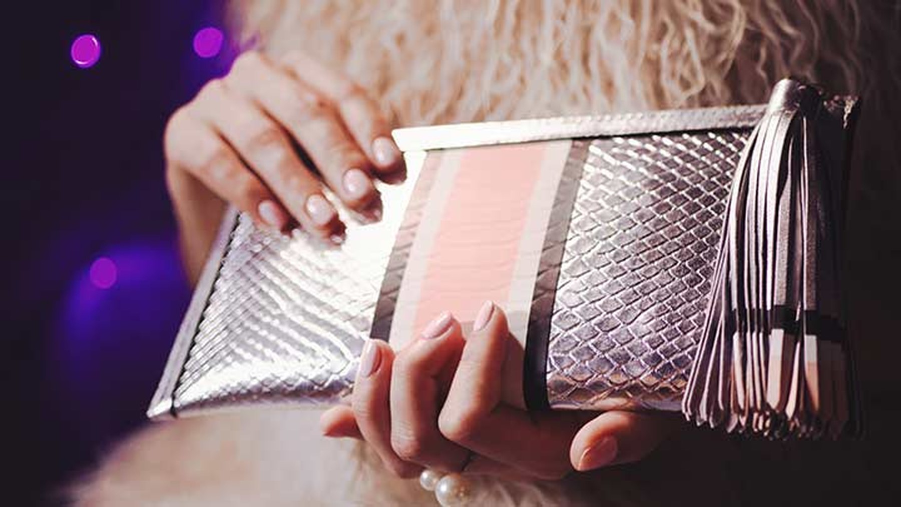 Silver clutch held by woman with manicure